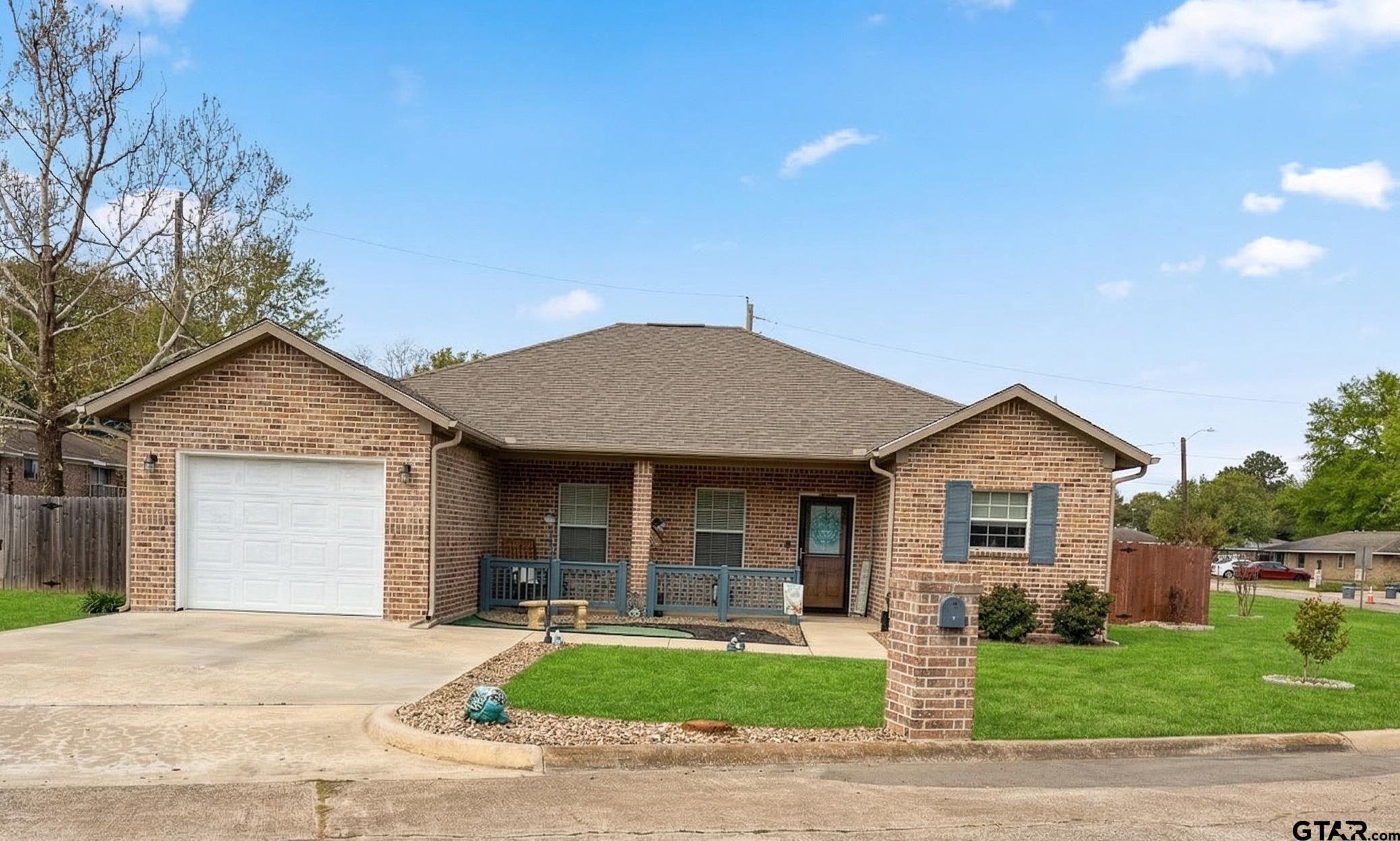 168 Tupelo Street Pittsburg, TX 75686 - Photo 1 of 28 a front view of a house with a yard and garage