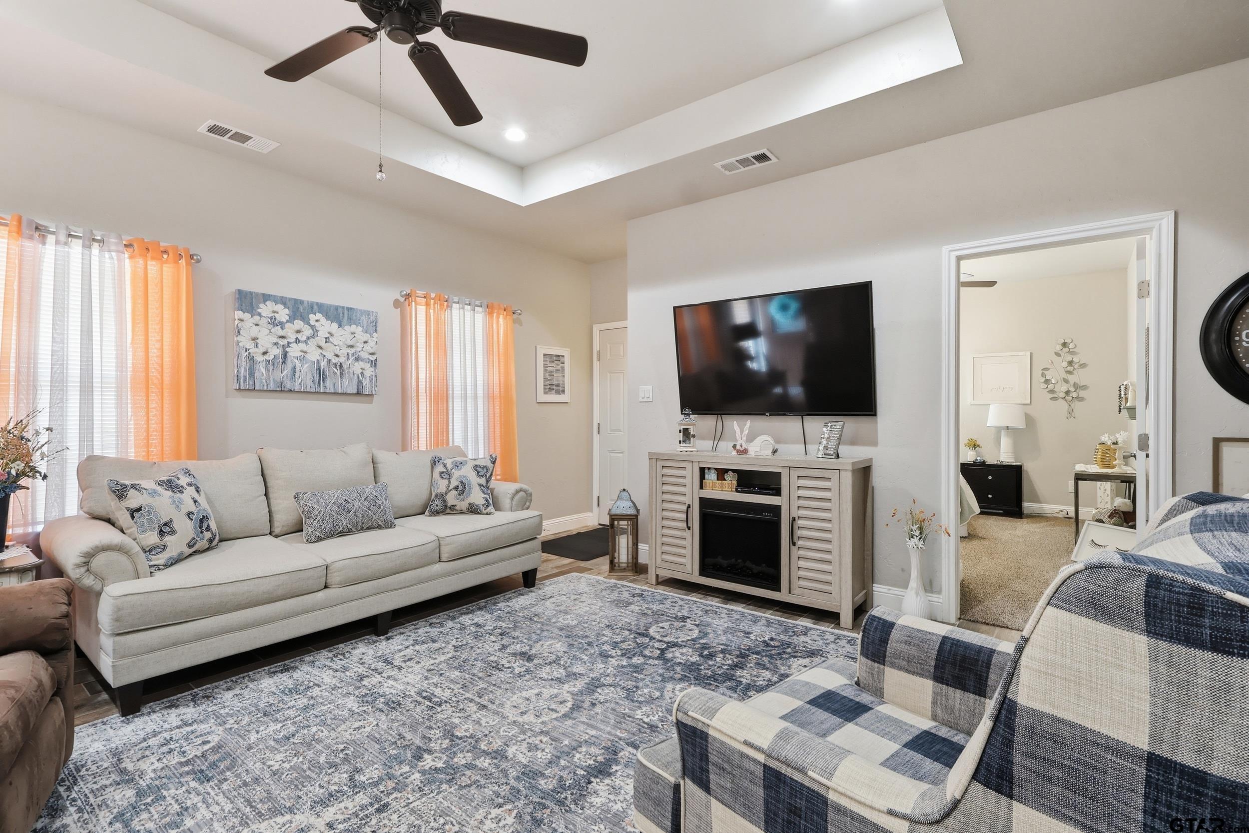 168 Tupelo Street Pittsburg, TX 75686 - Photo 12 of 28 a living room with furniture a flat screen tv and a fireplace