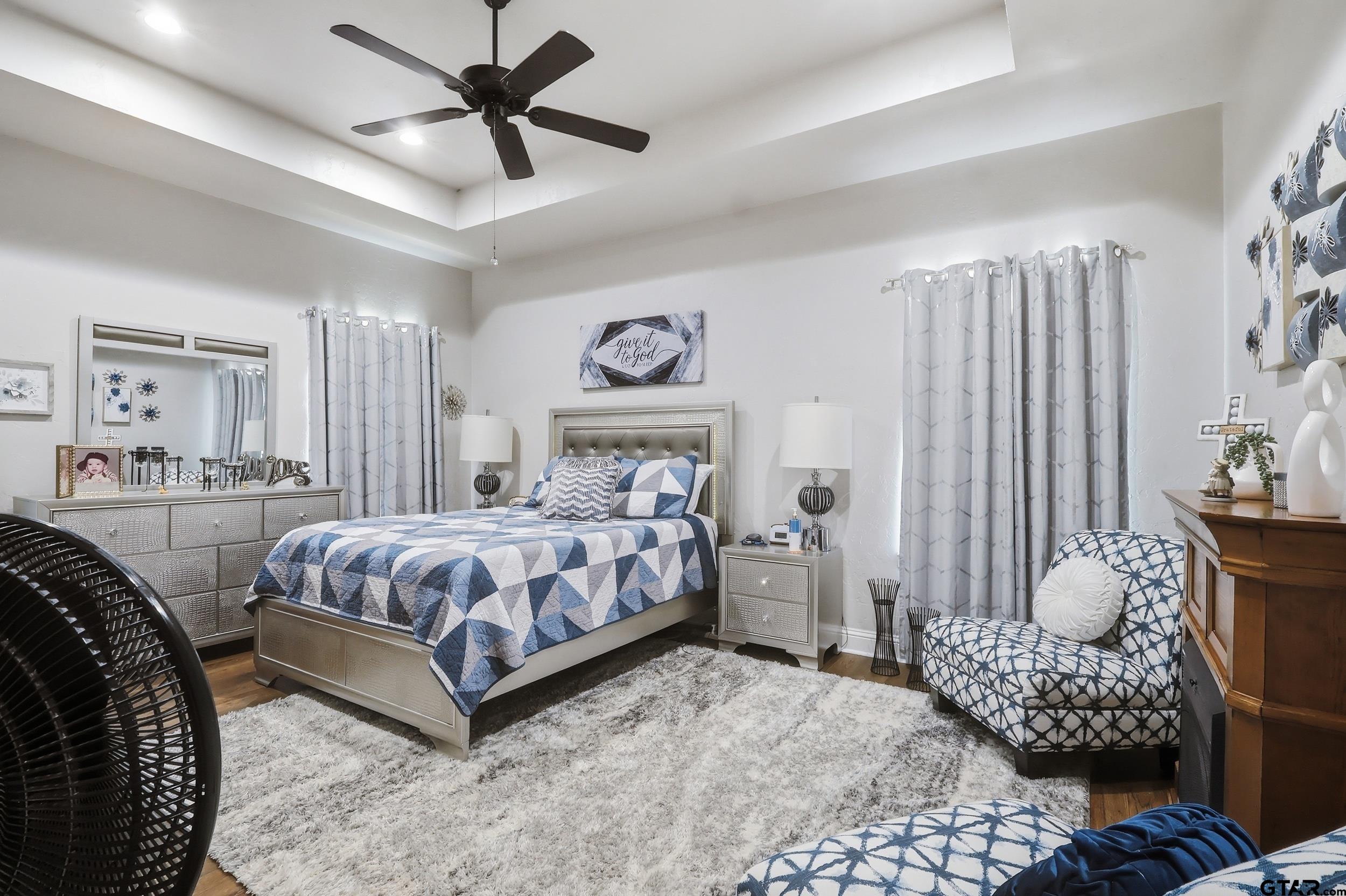 168 Tupelo Street Pittsburg, TX 75686 - Photo 16 of 28 a bedroom with a bed and a chandelier