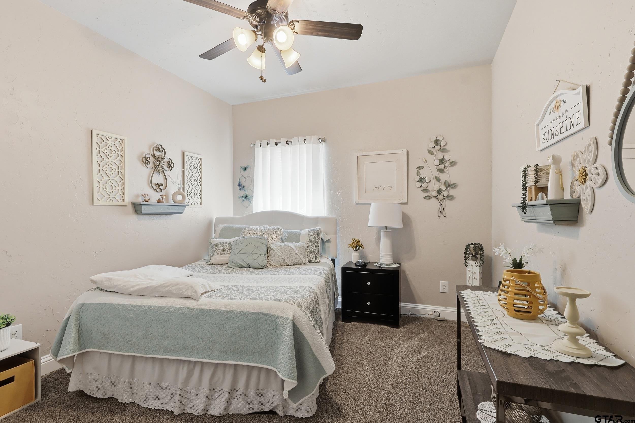 168 Tupelo Street Pittsburg, TX 75686 - Photo 19 of 28 a bedroom with a bed and a chandelier