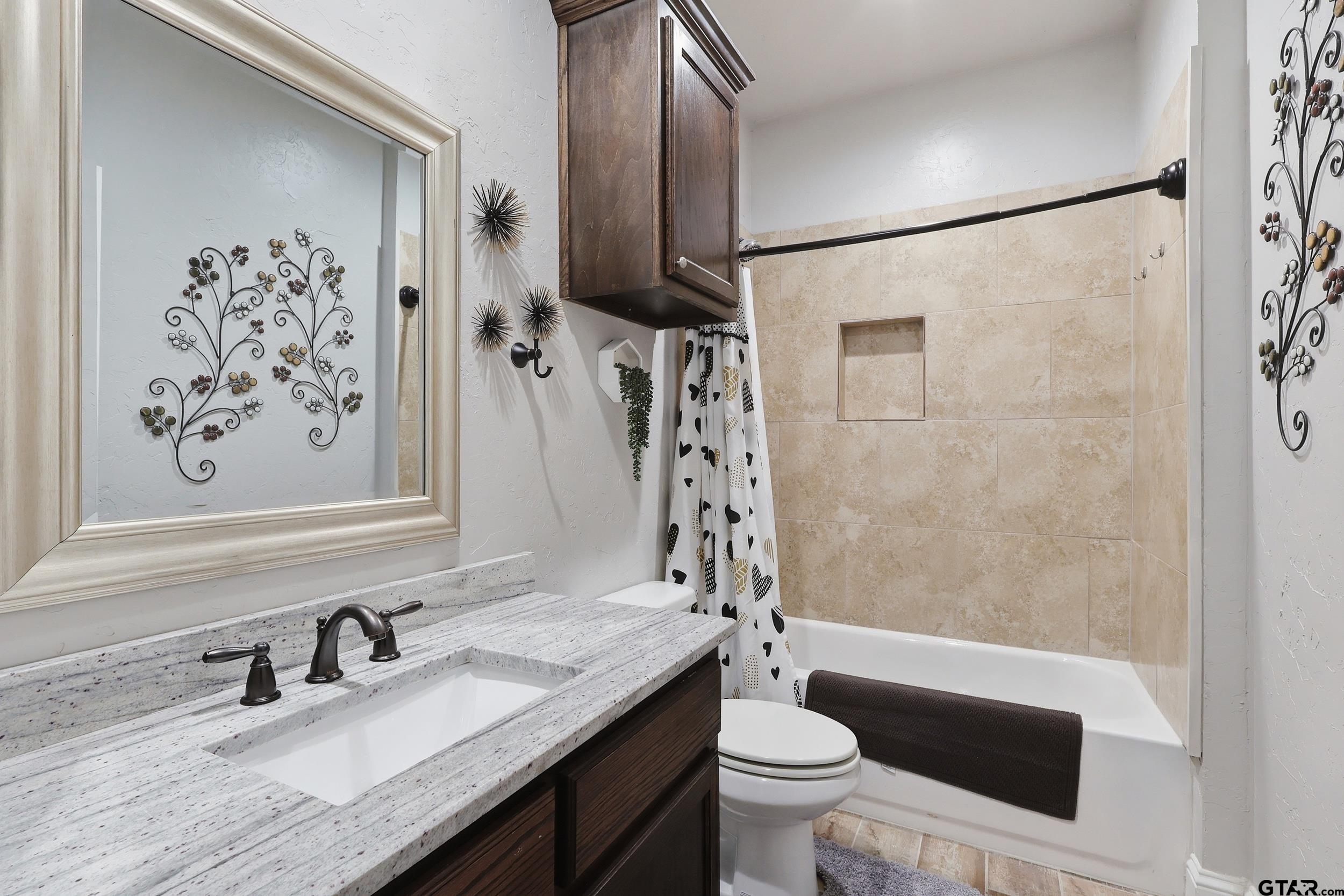 168 Tupelo Street Pittsburg, TX 75686 - Photo 21 of 28 a bathroom with a granite countertop sink toilet and shower