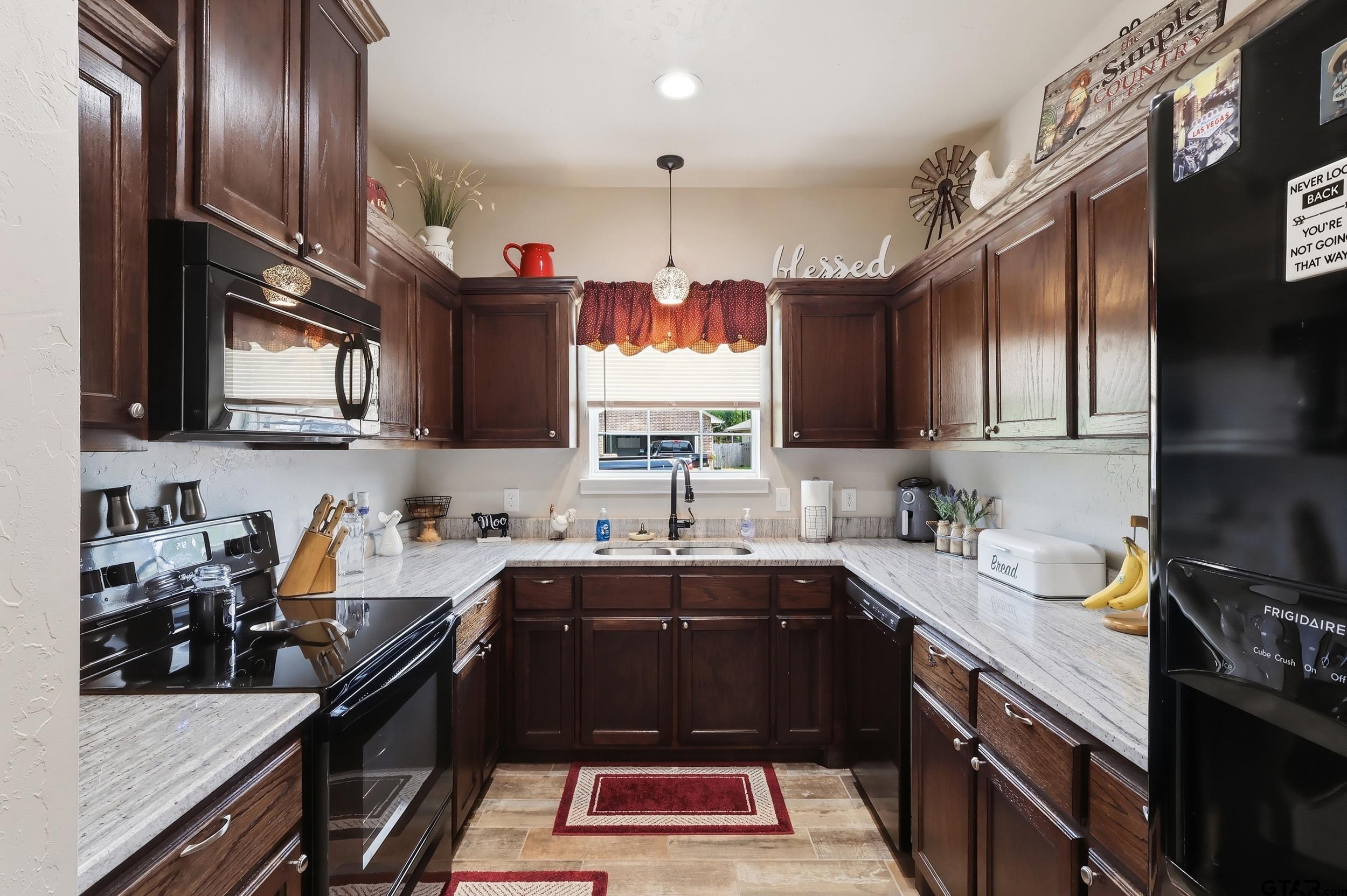 168 Tupelo Street Pittsburg, TX 75686 - Photo 6 of 28 a kitchen with a sink stainless steel appliances and cabinets