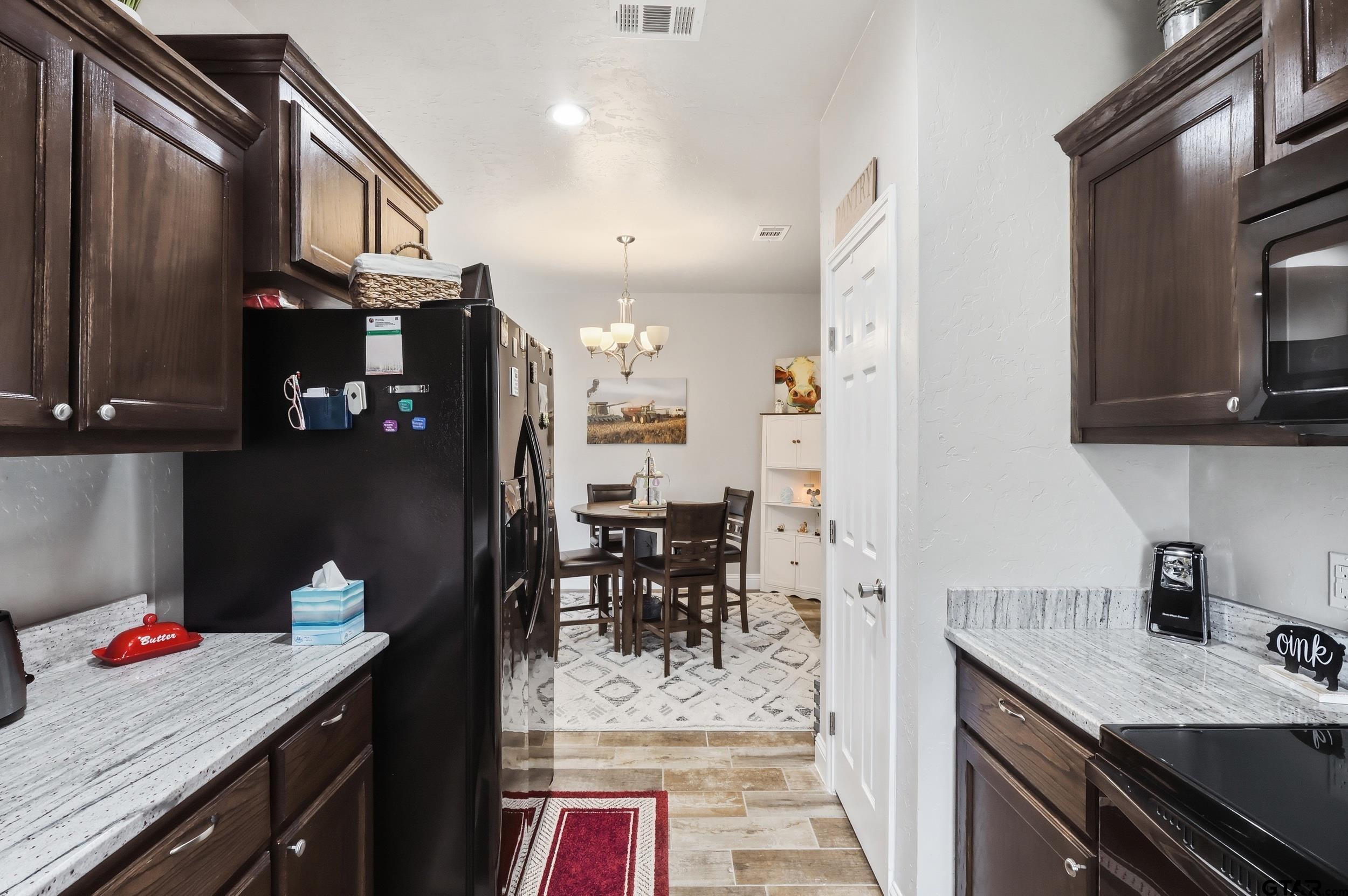 168 Tupelo Street Pittsburg, TX 75686 - Photo 7 of 28 a kitchen with granite countertop a sink stove and cabinets