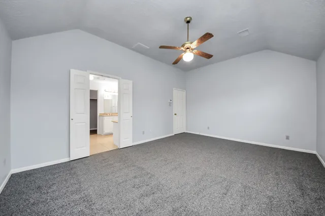 an empty room with windows and ceiling fan