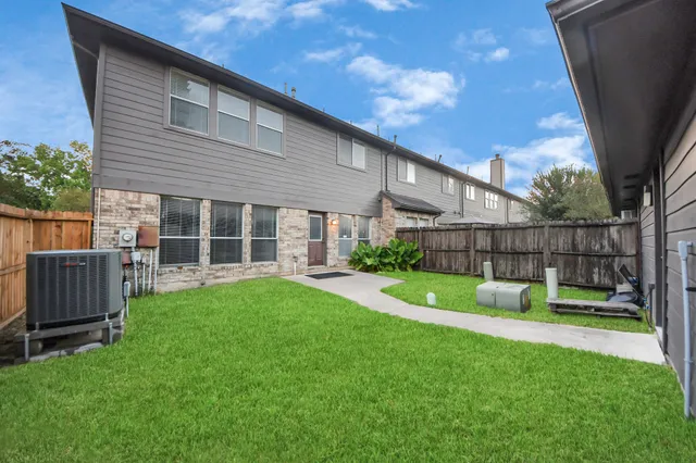 a view of house with backyard and a slide