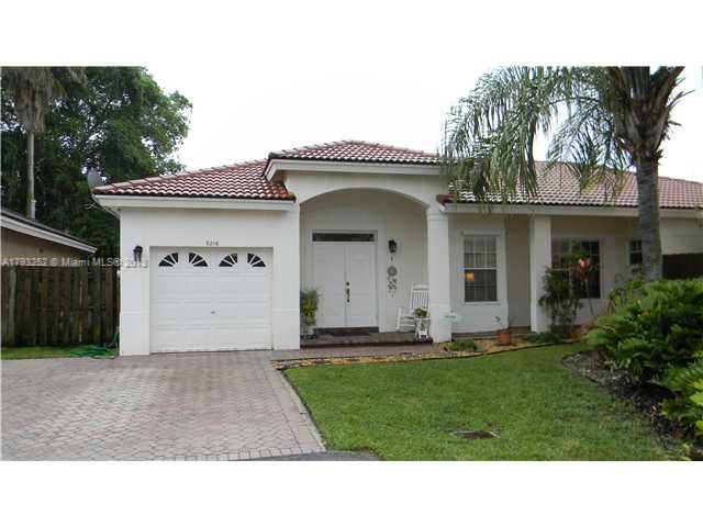 9216 Southwest 213th Lane Miami, FL 33189 - Photo 1 of 13 a front view of a house with a yard and garage