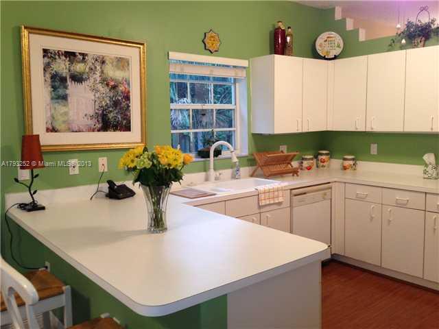 9216 Southwest 213th Lane Miami, FL 33189 - Photo 3 of 13 a kitchen with a sink a stove and cabinets