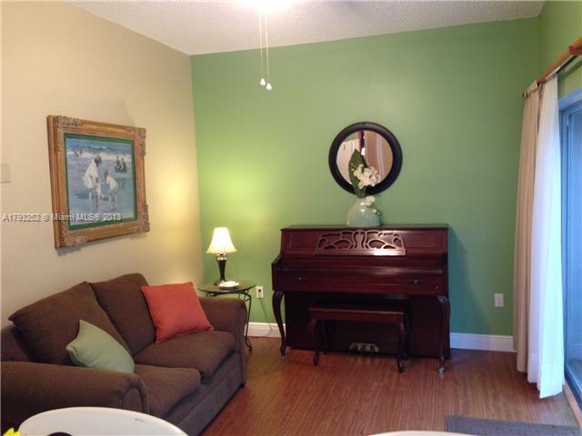 9216 Southwest 213th Lane Miami, FL 33189 - Photo 6 of 13 a living room with a couch and a mirror