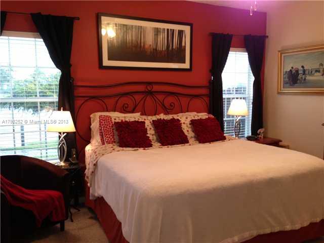 9216 Southwest 213th Lane Miami, FL 33189 - Photo 7 of 13 a bedroom with a bed and glass window