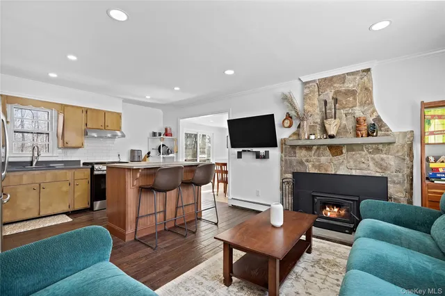 a living room with furniture a fireplace and kitchen view