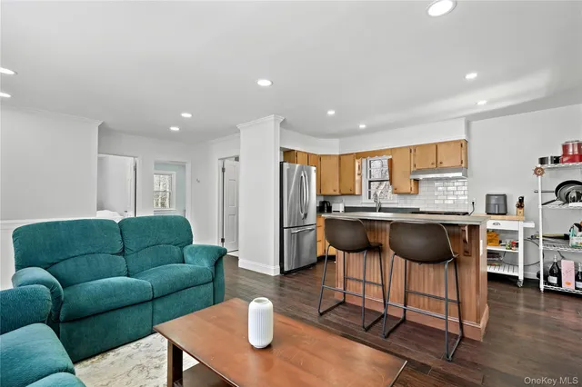 a living room with furniture a flat screen tv and kitchen view
