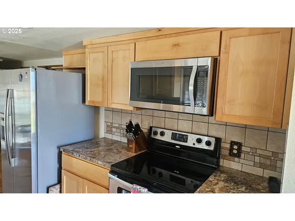 a kitchen with granite countertop a stove and a microwave
