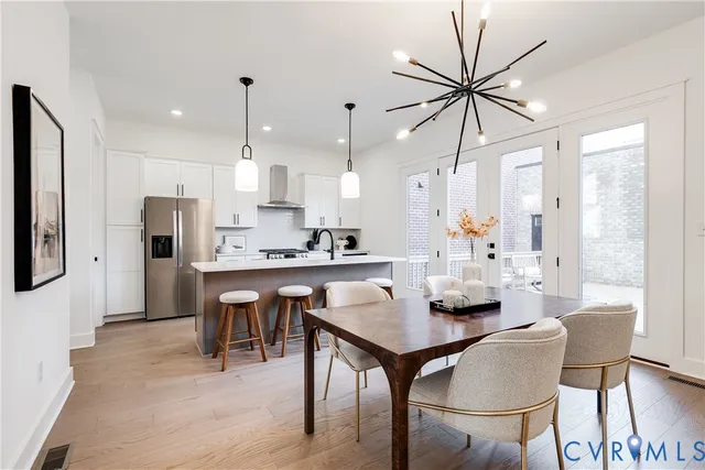 a kitchen with stainless steel appliances granite countertop a sink a stove a refrigerator and white cabinets