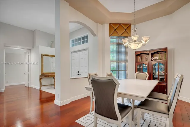 a view of a dining room with furniture wooden floor and chandelier