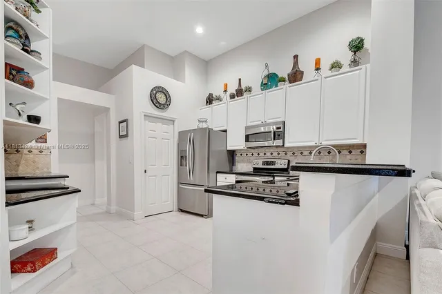 a kitchen with stainless steel appliances a refrigerator sink stove and cabinets