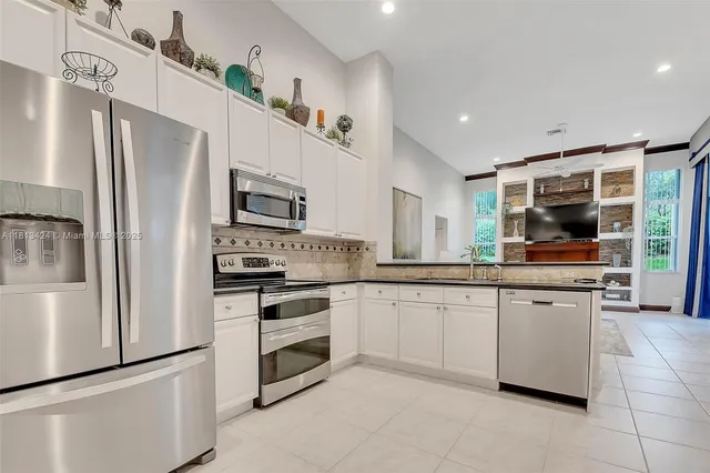 a kitchen with granite countertop white cabinets and stainless steel appliances