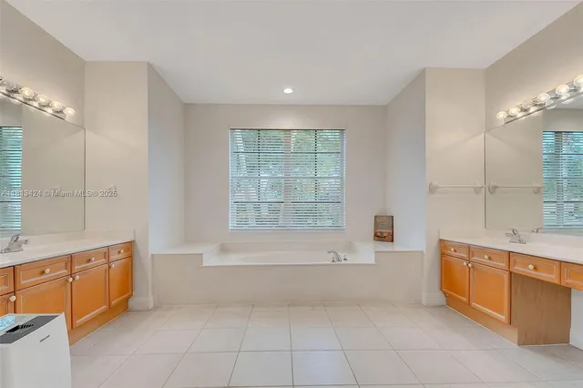 a spacious bathroom with a tub sink and mirror