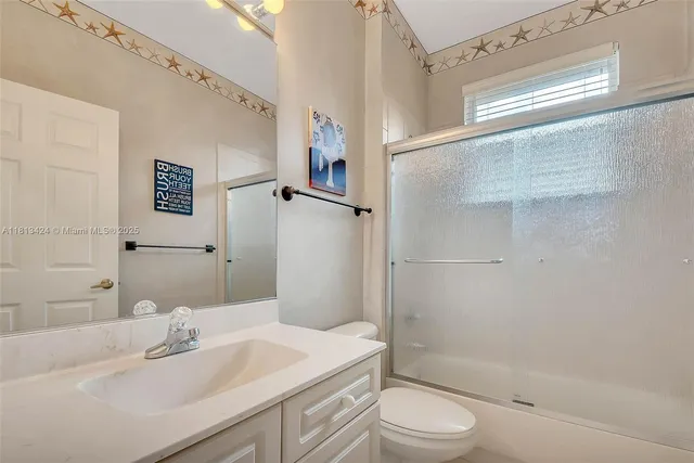 a bathroom with a sink toilet vanity and shower