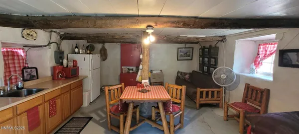 a kitchen with stainless steel appliances granite countertop a refrigerator a sink a stove with a dining table and chairs