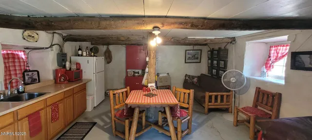 a kitchen with stainless steel appliances granite countertop a refrigerator a sink a stove with a dining table and chairs