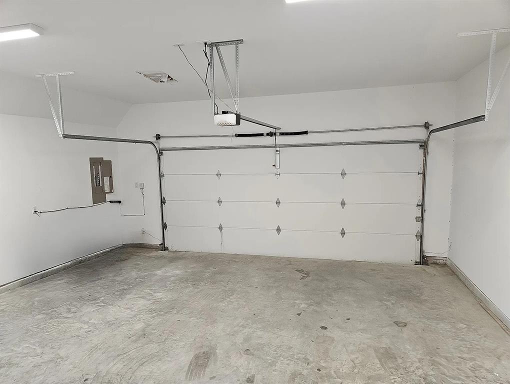 13325 Bee Street, Unit 406 Farmers Branch, TX 75234 - Photo 22 of 30 Garage featuring electric panel and baseboards