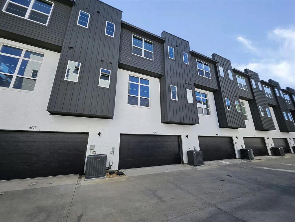 13325 Bee Street, Unit 406 Farmers Branch, TX 75234 - Photo 23 of 30 Rear view of property with board and batten siding and a residential view