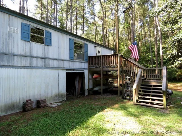 a view of a house with a small yard and wooden fence