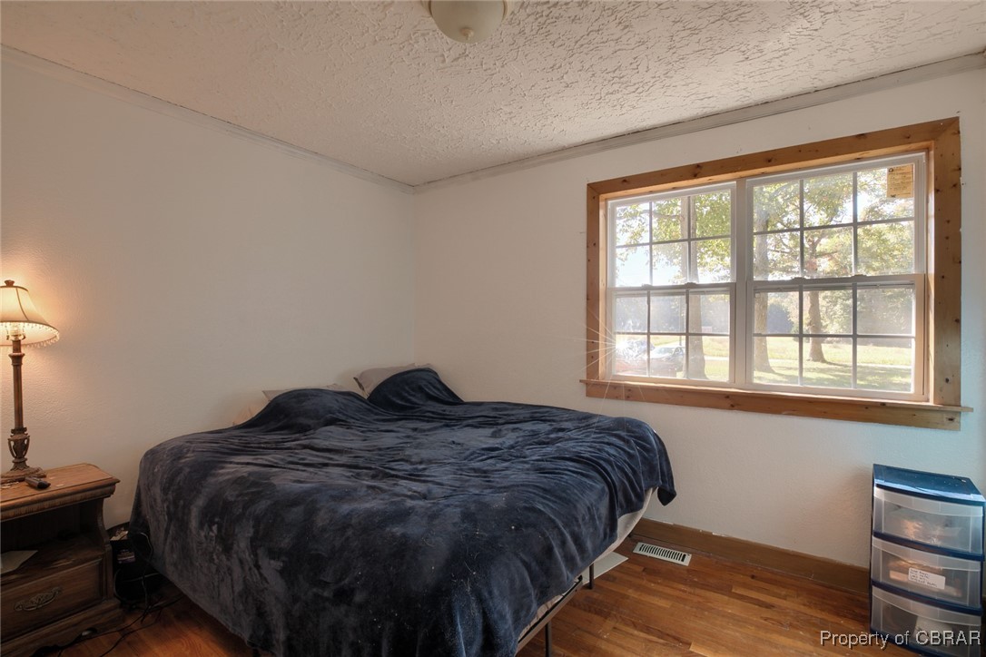 6153 Fletcher Road Gloucester, VA 23061 - Photo 10 of 16 Bedroom featuring hardwood / wood-style floors and a textured ceiling