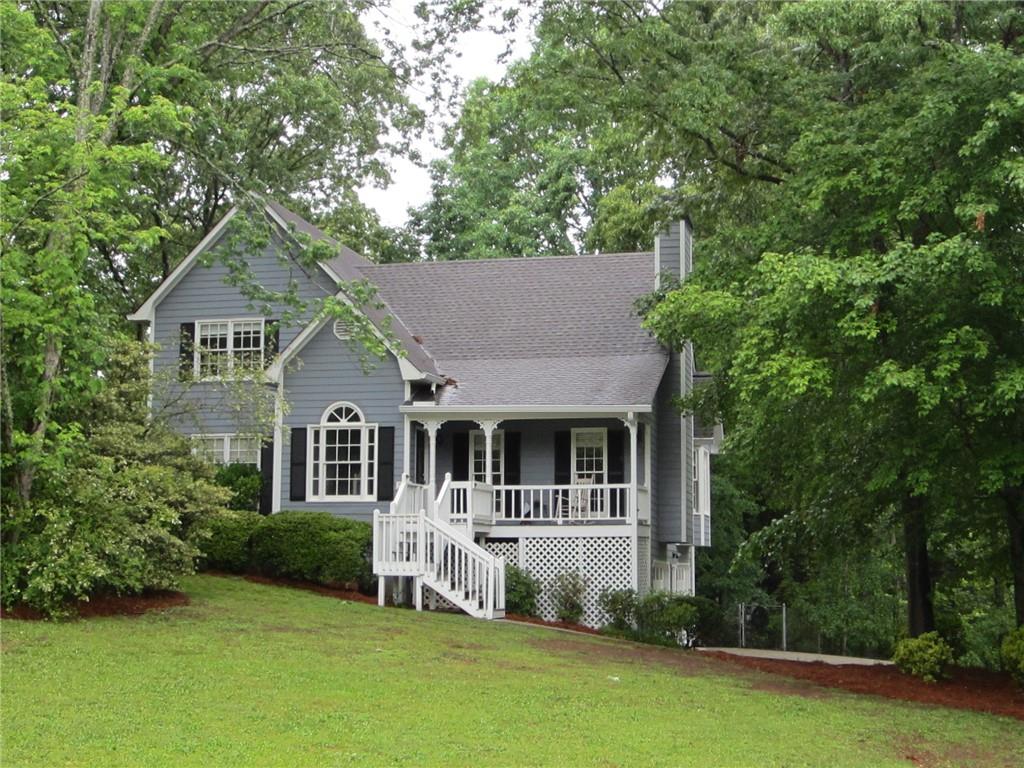 a front view of a house with a yard and green space
