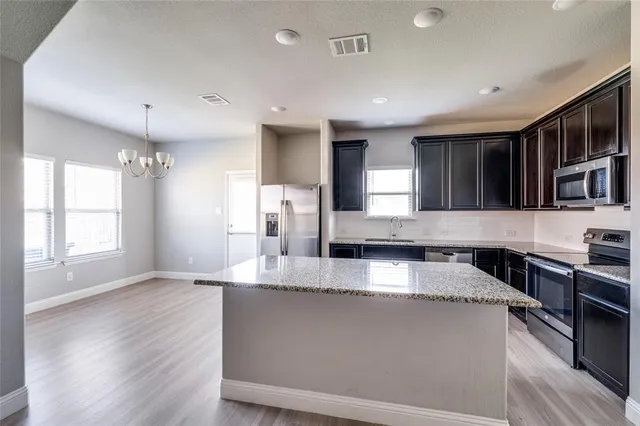 a large kitchen with stainless steel appliances granite countertop a large counter top a stove and a refrigerator