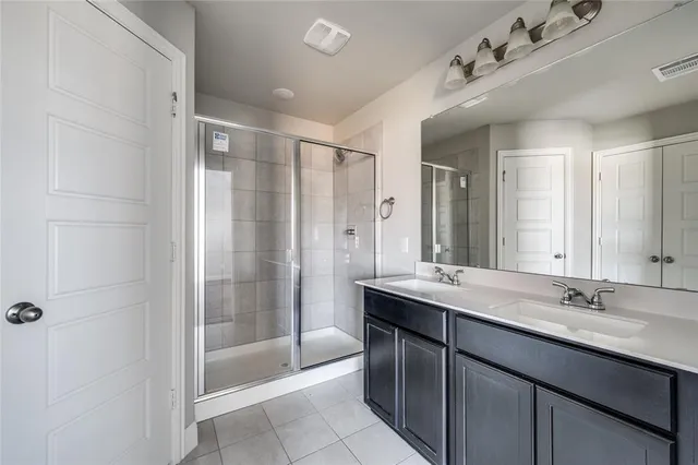 a bathroom with a double vanity sink mirror and shower