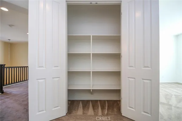 a view of walk in closet with empty racks