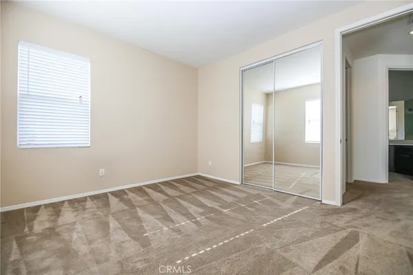 a view of an empty room with window and bathroom