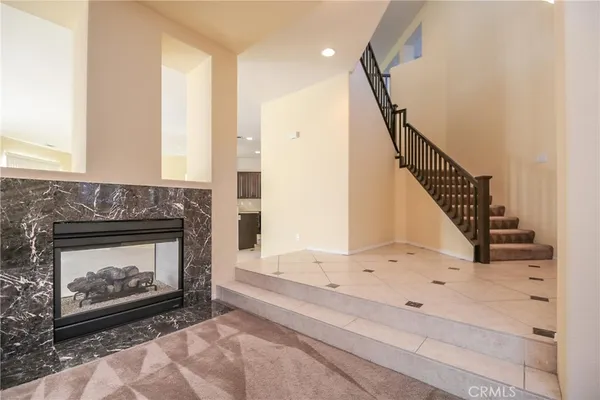 a view of an empty room with wooden floor fireplace and a window
