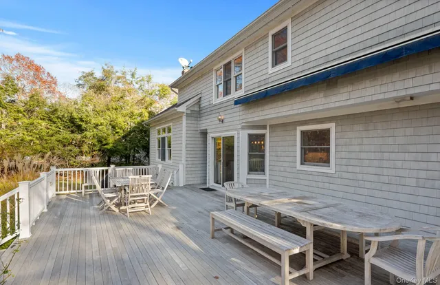 a balcony with table and chairs with wooden floor and fence