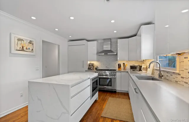 a kitchen with granite countertop a sink and white cabinets