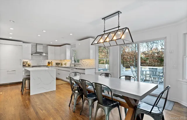 a view of a dining room and livingroom with furniture wooden floor a chandelier