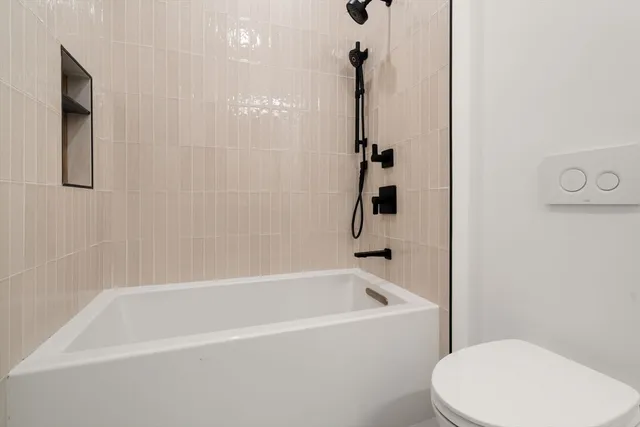 a white bath tub sitting next to a toilet