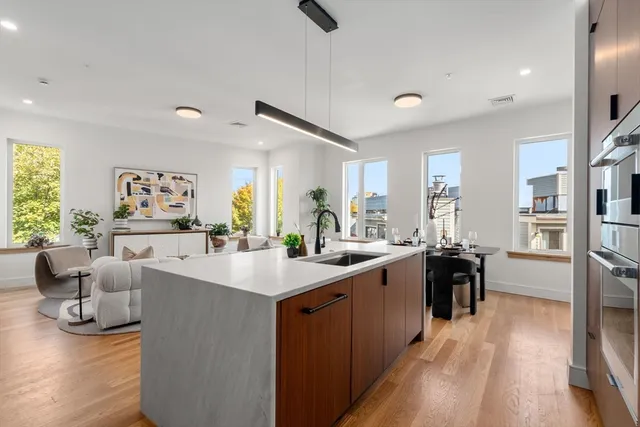 a large white kitchen with a large window and stainless steel appliances