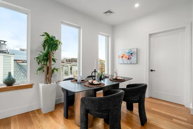 a dining room with furniture window and wooden floor