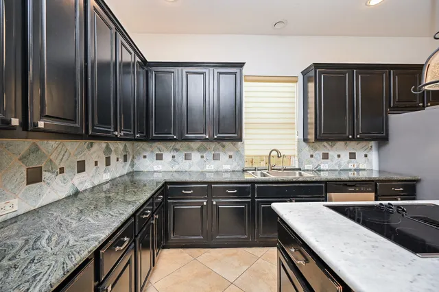 a kitchen with kitchen island granite countertop stainless steel appliances and refrigerator
