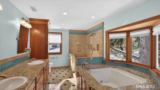 a bathroom with a granite countertop sink a mirror and a bathtub