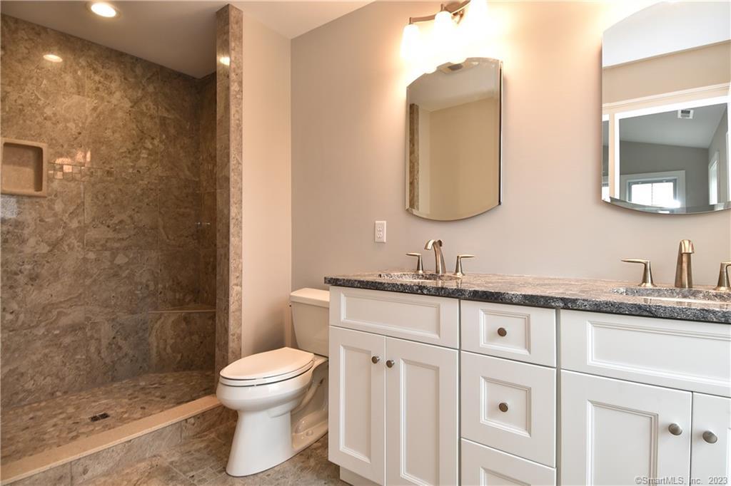 46 Village Crossing, Unit 46 Niantic, CT 06357 - Photo 16 of 24 a bathroom with a granite countertop toilet sink and mirror