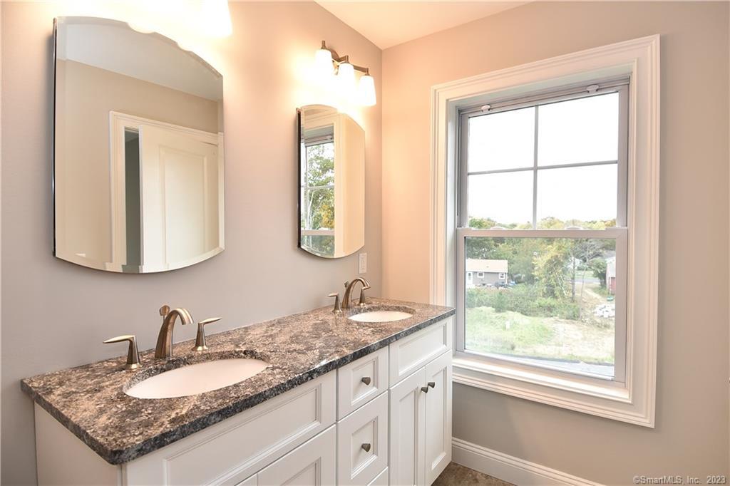 46 Village Crossing, Unit 46 Niantic, CT 06357 - Photo 18 of 24 a bathroom with a granite countertop sink and a mirror