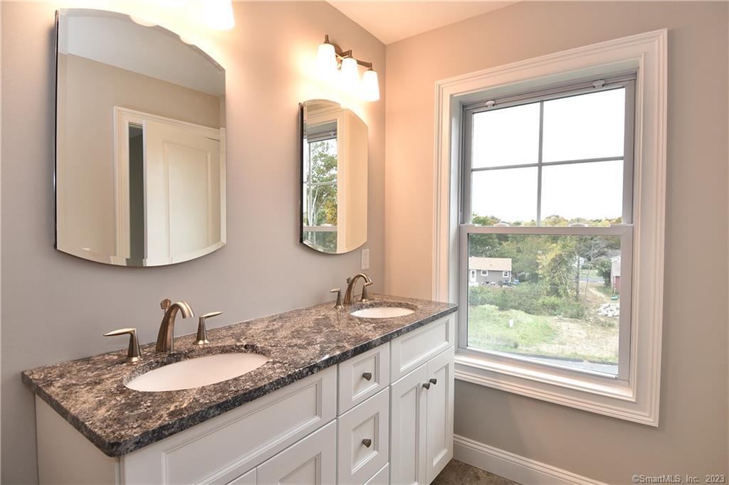 46 Village Crossing, Unit 46 Niantic, CT 06357 - Photo 19 of 24 a bathroom with a granite countertop sink and a mirror