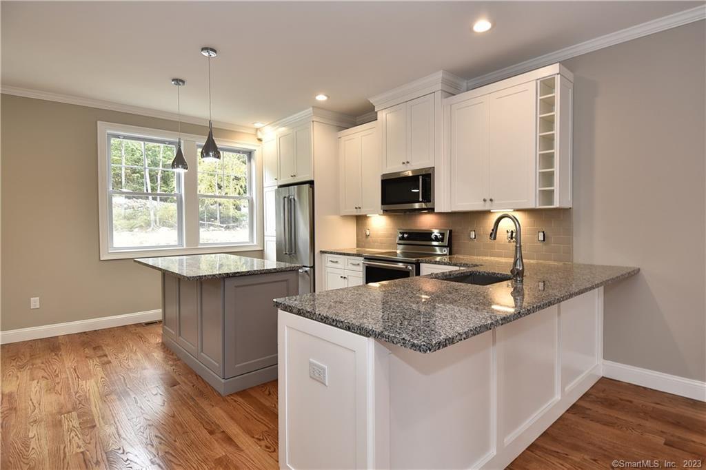 46 Village Crossing, Unit 46 Niantic, CT 06357 - Photo 2 of 24 a kitchen with granite countertop a sink a counter top space and cabinets