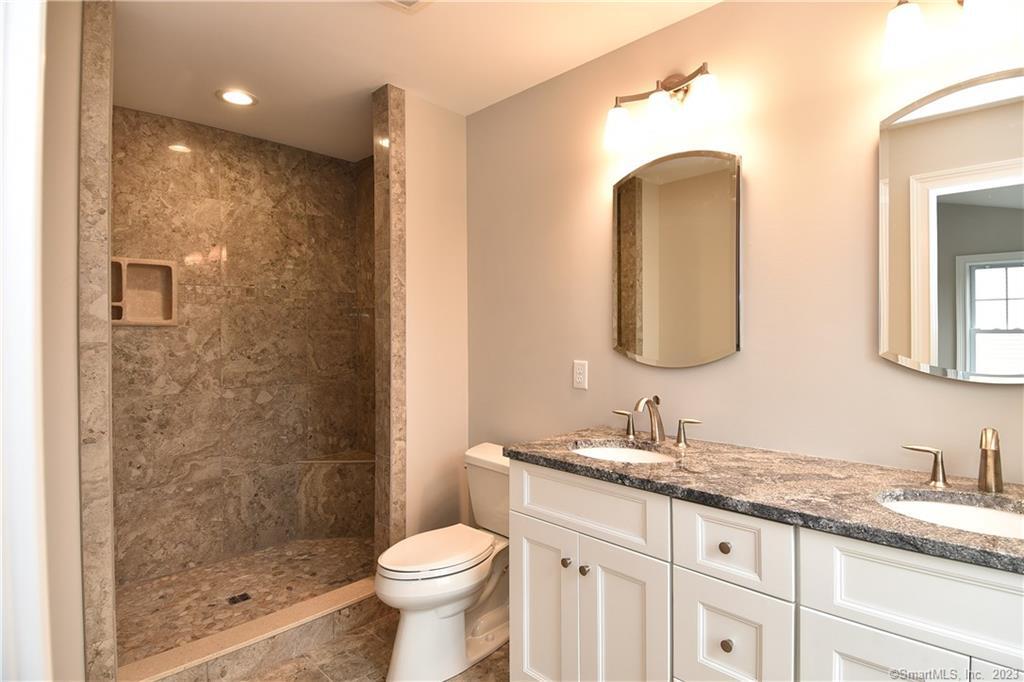 46 Village Crossing, Unit 46 Niantic, CT 06357 - Photo 20 of 24 a bathroom with a granite countertop sink mirror and toilet