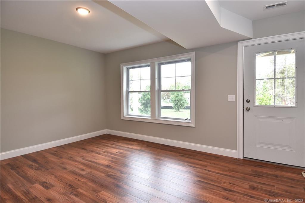 46 Village Crossing, Unit 46 Niantic, CT 06357 - Photo 22 of 24 an empty room with wooden floor and windows