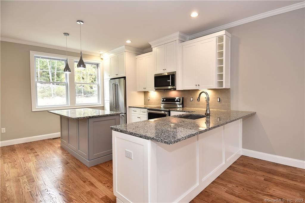 46 Village Crossing, Unit 46 Niantic, CT 06357 - Photo 3 of 24 a kitchen with stainless steel appliances granite countertop a sink stove and refrigerator