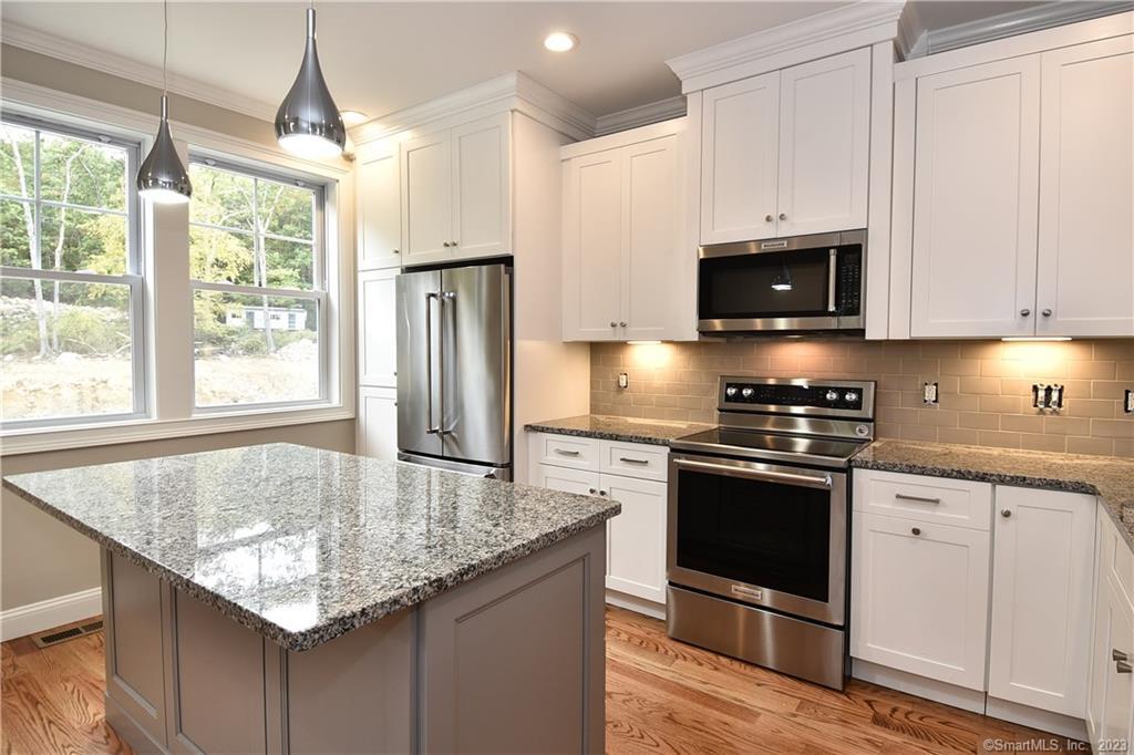 46 Village Crossing, Unit 46 Niantic, CT 06357 - Photo 5 of 24 a kitchen with granite countertop a sink cabinets and stainless steel appliances